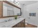 Bright bathroom features double sinks, with a tiled shower, and vanity with modern fixtures at 8931 W Alex Ave, Peoria, AZ 85382
