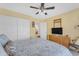 Comfortable bedroom with ceiling fan features closet, tv and dresser for a practical and cozy space at 8931 W Alex Ave, Peoria, AZ 85382