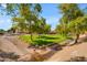 A view of a community park with green grass and trees with the road nearby at 8931 W Alex Ave, Peoria, AZ 85382