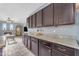 Kitchen featuring dark cabinetry, granite countertops, and stainless appliances with views to the living area at 8931 W Alex Ave, Peoria, AZ 85382