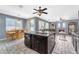 Open concept kitchen features dark cabinets, granite countertops, a large island, and stainless steel appliances at 8931 W Alex Ave, Peoria, AZ 85382