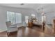 Bright primary bedroom with hardwood floors, ceiling fan, four-poster bed, sitting area, and lots of windows at 8931 W Alex Ave, Peoria, AZ 85382