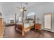 Spacious primary bedroom with four-poster bed, hardwood floors, ceiling fan, and sitting area with a fireplace at 8931 W Alex Ave, Peoria, AZ 85382