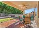 Inviting covered patio features wood-look tile, a ceiling fan, and relaxing seating near the pool and landscaped yard at 8931 W Alex Ave, Peoria, AZ 85382