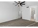 Bedroom with neutral carpet, ceiling fan, and doorway to an en-suite bathroom at 896 N Kingston St, Gilbert, AZ 85233