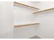 Walk-in closet with adjustable wooden shelves and neutral carpet at 896 N Kingston St, Gilbert, AZ 85233