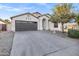 Inviting single-story home featuring a wide driveway and a welcoming front entrance with desert landscaping at 896 N Kingston St, Gilbert, AZ 85233