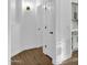 Hallway with wood-look flooring, white walls, and doorway to the kitchen at 896 N Kingston St, Gilbert, AZ 85233
