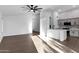 Open-concept living space with sleek flooring, a ceiling fan, and modern paint with an adjacent kitchen at 896 N Kingston St, Gilbert, AZ 85233