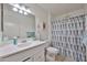 Clean bathroom features a large mirror and shower with a patterned curtain at 10648 W Loma Blanca Dr, Sun City, AZ 85351