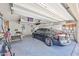 Well-lit garage features overhead storage and a parked car at 10648 W Loma Blanca Dr, Sun City, AZ 85351