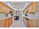 Bright kitchen featuring wooden cabinets, tile flooring, and a skylight providing ample natural light at 10648 W Loma Blanca Dr, Sun City, AZ 85351
