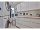 Neat laundry room featuring white cabinets, a stacked washer/dryer, and ample counter space at 10648 W Loma Blanca Dr, Sun City, AZ 85351