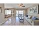 Spacious living room featuring wood flooring, patio access, and comfortable seating at 10648 W Loma Blanca Dr, Sun City, AZ 85351