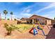 Backyard with a lawn, playset, and drought-resistant landscaping around the perimeter at 13022 W Cherry Hills Dr, El Mirage, AZ 85335