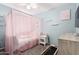 Light and airy bedroom featuring a pink canopy bed, neutral carpet, and blue accent wall at 13022 W Cherry Hills Dr, El Mirage, AZ 85335