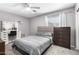 Comfortable bedroom showcasing a tufted headboard, a vanity and a dark dresser at 13022 W Cherry Hills Dr, El Mirage, AZ 85335