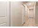 Bright hallway featuring neutral walls and tiled floors with multiple access doors at 13022 W Cherry Hills Dr, El Mirage, AZ 85335