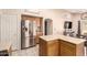 Spacious kitchen with stainless steel refrigerator, wooden cabinetry, and connecting breakfast nook at 13022 W Cherry Hills Dr, El Mirage, AZ 85335