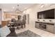 Open-concept living area with dining table, entertainment center, and stainless steel kitchen at 13022 W Cherry Hills Dr, El Mirage, AZ 85335