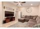 Relaxing living room featuring a comfortable sectional sofa, ceiling fan, and tiled flooring at 13022 W Cherry Hills Dr, El Mirage, AZ 85335