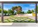 View of backyard featuring decorative pavers and artificial turf, and lush landscaping and mature shade trees at 1304 W Ocotillo Rd, Phoenix, AZ 85013