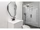 Modern bathroom featuring a frameless glass shower, unique mirror and sleek vanity with black hardware at 1304 W Ocotillo Rd, Phoenix, AZ 85013