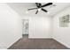Bedroom features carpet, a ceiling fan, a window, and an entry to a bright bathroom at 1304 W Ocotillo Rd, Phoenix, AZ 85013