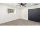 Bright bedroom with neutral carpet, a ceiling fan, and a closet with black sliding doors at 1304 W Ocotillo Rd, Phoenix, AZ 85013