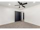 Bright bedroom with neutral carpet, a ceiling fan, and closet with black sliding doors at 1304 W Ocotillo Rd, Phoenix, AZ 85013