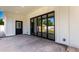Covered patio featuring a black bi-fold glass doors, leading to a serene outdoor space and lush greenery at 1304 W Ocotillo Rd, Phoenix, AZ 85013