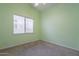 Bedroom painted light green with neutral carpet and window overlooking front yard at 15809 S 31St St, Phoenix, AZ 85048