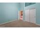 Bedroom featuring neutral carpet, light blue walls, and closet with bi-fold doors at 15809 S 31St St, Phoenix, AZ 85048