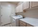 Functional laundry room includes a washer, dryer, storage cabinets, and a utility sink at 15809 S 31St St, Phoenix, AZ 85048