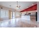 An open-concept room showcasing a red accent wall, a ceiling fan, tile flooring, and a view to the backyard at 15809 S 31St St, Phoenix, AZ 85048