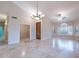 Open-concept living area with a large window, ceiling fan, tile flooring, and a stylish chandelier at 15809 S 31St St, Phoenix, AZ 85048