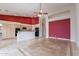 Bright living room features an open-concept layout, a red accent wall, a ceiling fan and tile flooring at 15809 S 31St St, Phoenix, AZ 85048