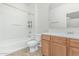 Clean bathroom with white tub/shower combo, oak cabinets, and neutral tile floor at 15941 N 171St Ln, Surprise, AZ 85388