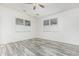 Neutral bedroom features wood-look flooring, two windows with blinds, and a ceiling fan at 15941 N 171St Ln, Surprise, AZ 85388