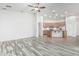 Open floor plan features wood-look flooring, a ceiling fan, and an archway leading to the kitchen at 15941 N 171St Ln, Surprise, AZ 85388
