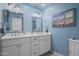Bathroom with double sinks, white cabinets, and beach-themed decor creates a serene atmosphere at 17 W Vernon Ave # 31, Phoenix, AZ 85003