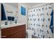 Well-lit bathroom features a dark vanity, with a toilet and shower/tub combo with a bird themed curtain at 17 W Vernon Ave # 31, Phoenix, AZ 85003