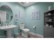 This bathroom is adorned with succulents artwork, pedestal sink, and a round mirror at 17 W Vernon Ave # 31, Phoenix, AZ 85003