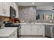 The gourmet kitchen features white cabinets, countertops, stainless appliances, and mosaic backsplash at 17 W Vernon Ave # 31, Phoenix, AZ 85003