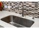 This kitchen features a modern sink, faucet, and elegant backsplash tiling at 17 W Vernon Ave # 31, Phoenix, AZ 85003