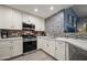Updated kitchen features white cabinets, countertops, stainless appliances, and mosaic backsplash at 17 W Vernon Ave # 31, Phoenix, AZ 85003
