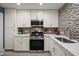 Beautiful kitchen featuring white cabinets, countertops, stainless appliances, and mosaic backsplash at 17 W Vernon Ave # 31, Phoenix, AZ 85003
