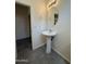Bathroom with pedestal sink, modern light fixture, and tiled floors at 1725 W Pollack St, Phoenix, AZ 85041