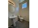 Bathroom with pedestal sink, modern light fixture, and tiled floors at 1725 W Pollack St, Phoenix, AZ 85041