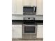 Close-up of Whirlpool stainless steel oven, microwave, and cooktop against white cabinets at 1725 W Pollack St, Phoenix, AZ 85041